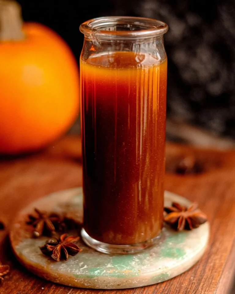 Homemade pumpkin spice syrup in a glass bottle with fall spices around it