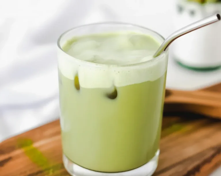 Creamy Matcha Protein Coffee Latte served in a glass with a swirl of milk.