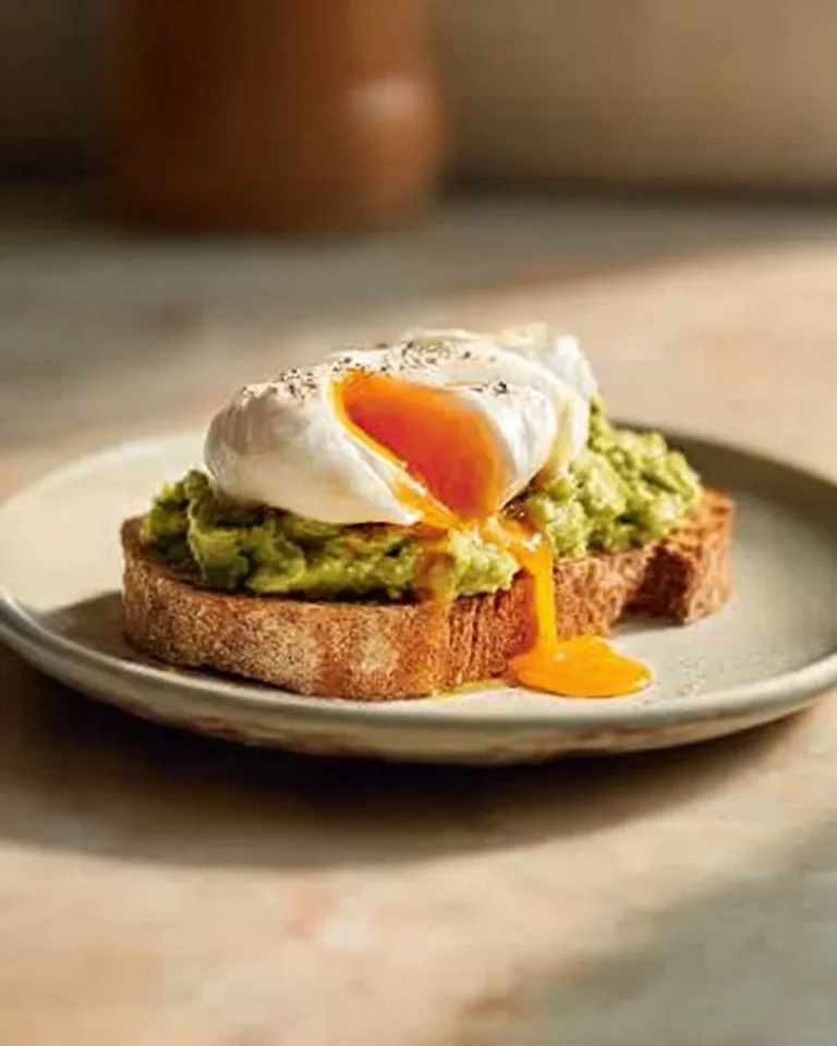 Delicious poached egg avocado toast on a plate garnished with herbs